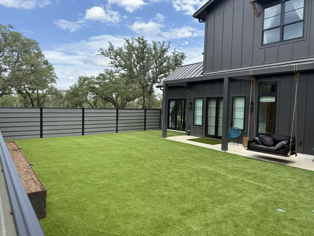 Artificial turf beside a modern home, installed by Solstice Outdoors