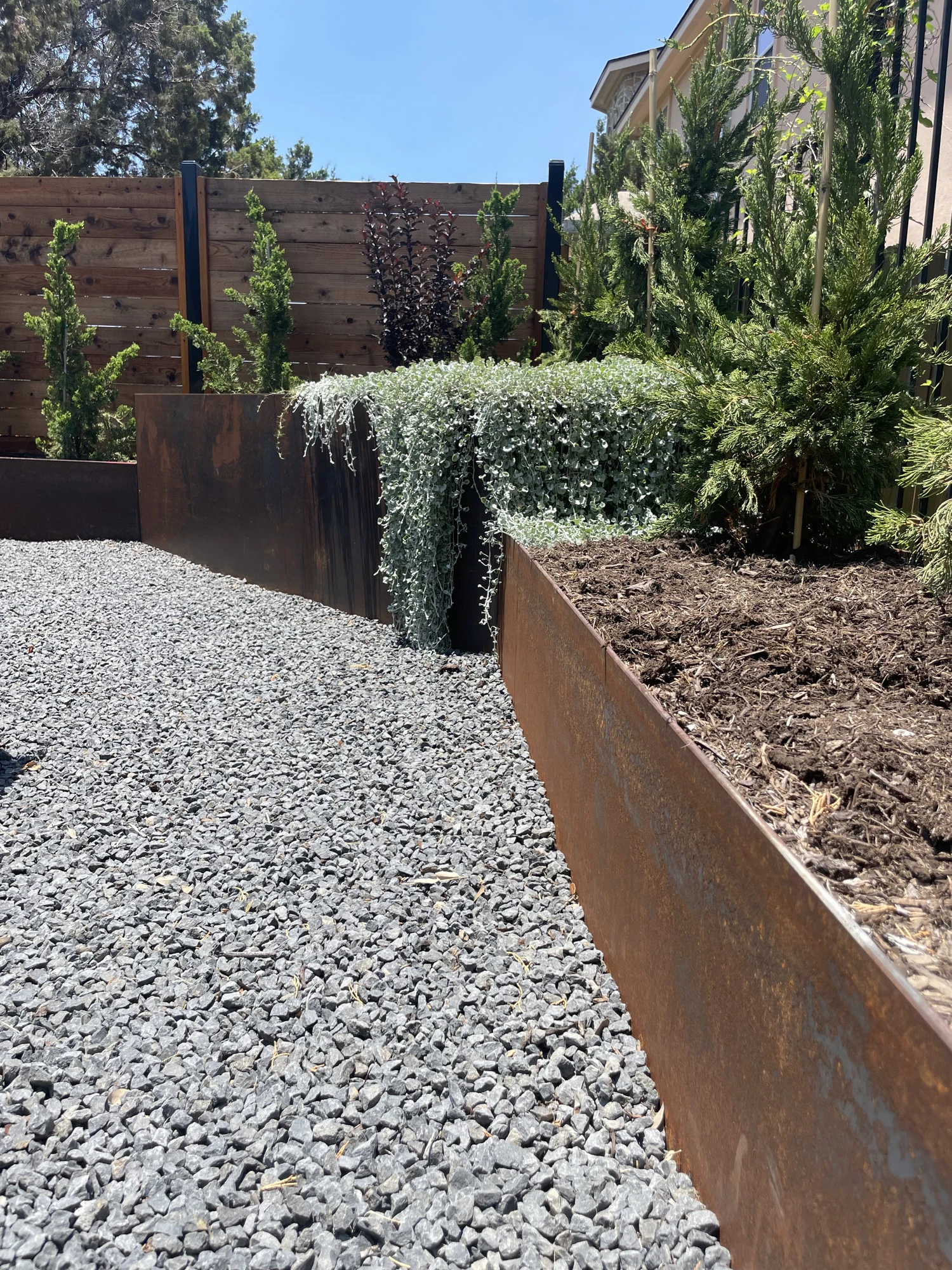 Custom steel planter edging with gravel and planting